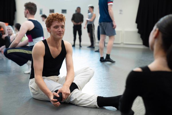 Dancers sit in the studio in conversation