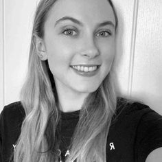 A White British woman, in her mid-20s, with light-coloured mid-length hair, smiling towards the camera