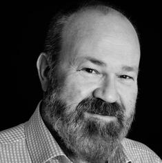 Man with beard, smiles warmly