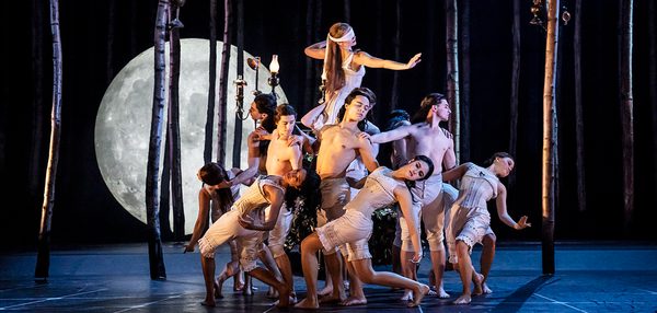 Aurora moves among the sleepwalkers. She is lifted above them and stretches her arms out like she is searching. The sleepwalkers gather around her in a moving formation.