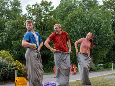Three dancers all bounce around in sleeping bags.