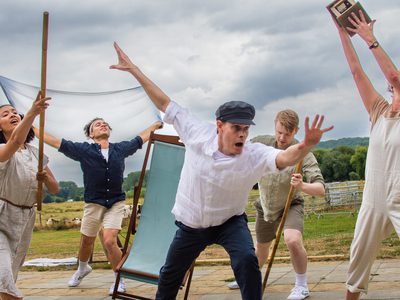 A cast of five dancers enact a scene at sea